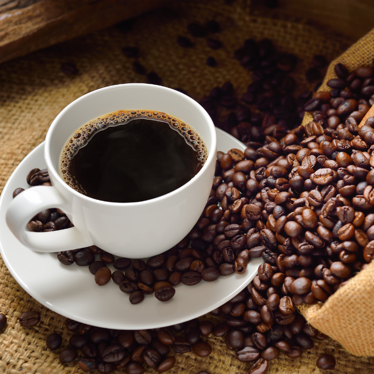 Schwarzer Kaffee in einer Tasse, auf Kaffeesäcken und Kaffeebohnen